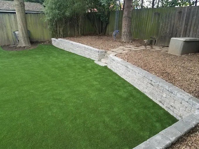 Artificial turf lawn with a low block retaining wall