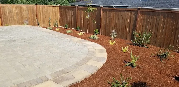 Fresh bark mulch bed along a curved paver patio
