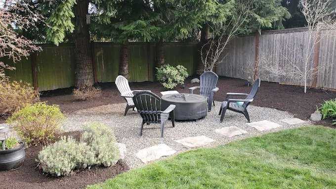 Fire pit seating area with Adirondack chairs on pea gravel
